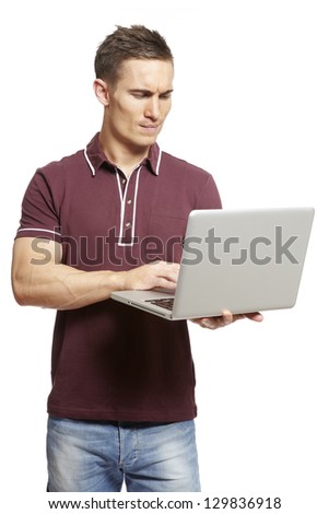 Young man using laptop on white background looking confused
