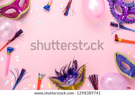 Table top view aerial image of beautiful colorful carnival season or photo booth prop Mardi Gras background.Flat lay objects colorful mask with confetti and decorations to party on pink paper.