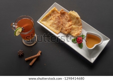 Pancakes on a rectangular white plate with tea