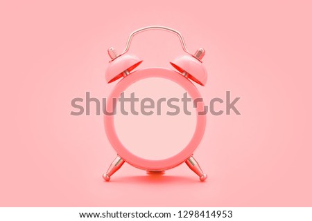 Living coral alarm clock with empty face, no hands, on trendy coral color background. Minimal creative concept. Copy space.