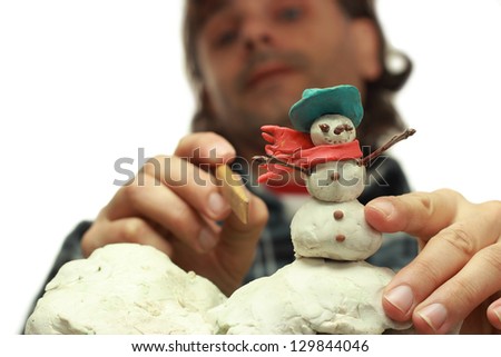 traditional clay animator at work on snowman miniature