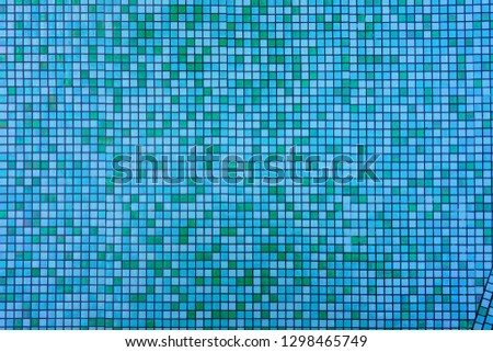 Mixed blue colored square tile mosaic background underwater in a swimming pool
