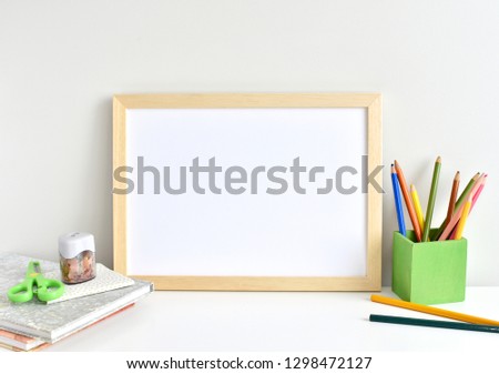 Wooden frame mockup, kids desk with pencils and books.
