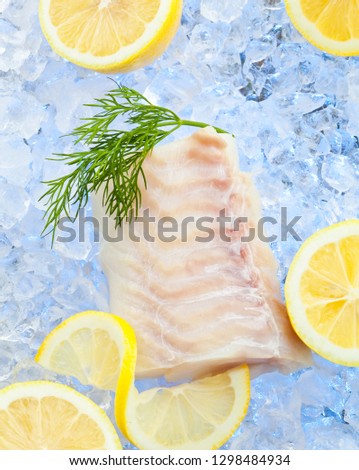 Cod fish fillets on ice with fresh Lemon 