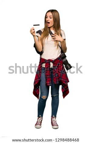 Full body Young photographer woman holding a credit card and surprised on isolated background