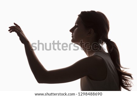 Silhouette of a young girl touching something on a white background