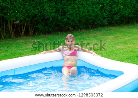 Happy girl playing in the Garden pool.
