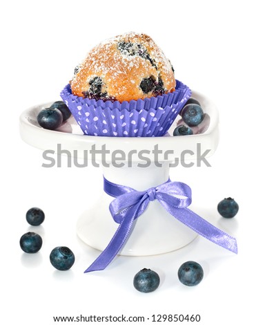 Blueberry muffin and some berries on a white plate, isolated
