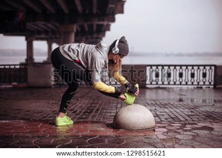 Potrtait of young woman athlete doing exercises at morning in winter