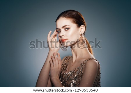 beautiful elegant woman wearing a gold dress model looks celebrity on a dark isolated background