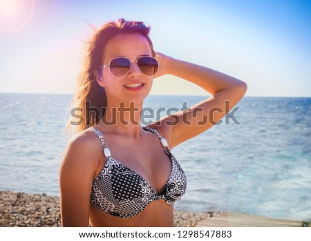 Happy woman on the beach. Portrait of a beautiful girl close-up on sea background. Spring portrait on the beach. Young pretty girl. Young smiling woman outdoors portrait. Close. ocean