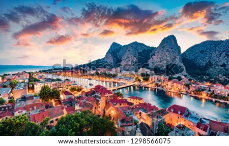 Aerial evening cityscape of old croatian resort - Omis town. Fantastic summer seascape of Adriatic sea, Dalmatia coast, Croatia, Europe. Beautiful world of Mediterranean countries.  Royalty-Free Stock Photo #1298566075