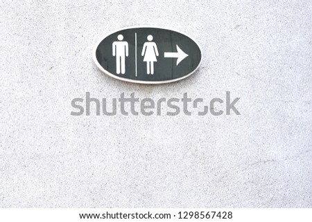 Toilet signs for men and women on a white marble wall