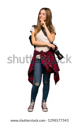Full body Young photographer woman looking to the side with the hand on the chin on isolated background