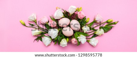 Easter background with Easter eggs and spring flowers. Top view with copy space. Nest with eggs decorated with beautiful flowers on a pink background.