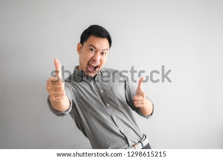 Happy face of funny good looking Asian man with hand sign pointing.