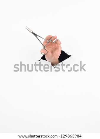 close-up of female hand holding a mosquito forceps through a torn white paper, isolated