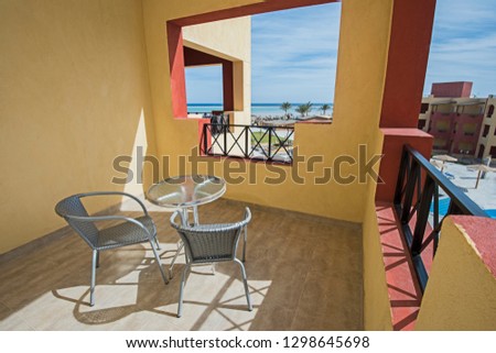 View from a balcony terrace of luxury hotel resort room with swimming pool and sea view