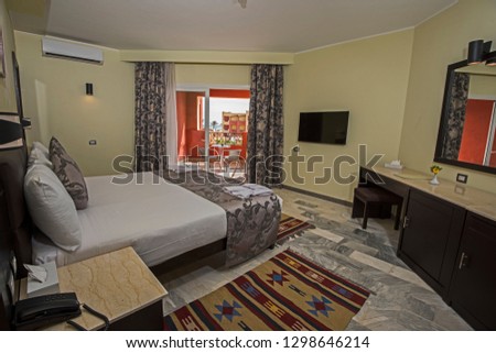 Double bed in suite of a luxury hotel room with lounge and curtains