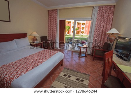 Double bed in suite of a luxury hotel room with balcony and curtains