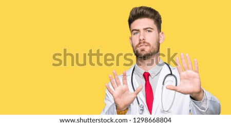 Young handsome doctor man wearing medical coat Smiling doing frame using hands palms and fingers, camera perspective