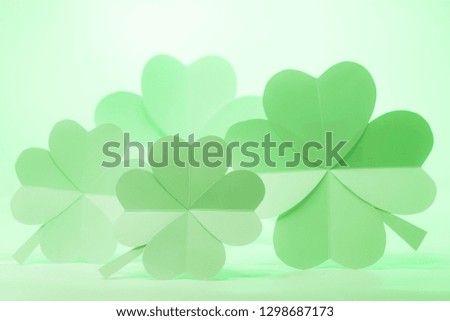 Hand made 4 paper lucky four-leaf clovers on the rustic wooden
table.
