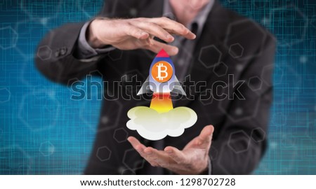 Bitcoin rise concept between hands of a man in background