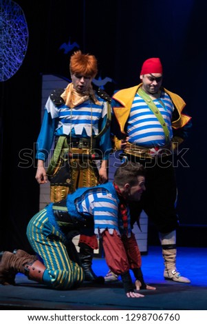Actors in pirate costumes play a performance for children on the theater stage