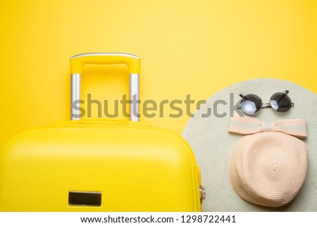 The flat lay a yellow suitcase with accessories for relaxing on a yellow background. concept of travel, rest and relaxation