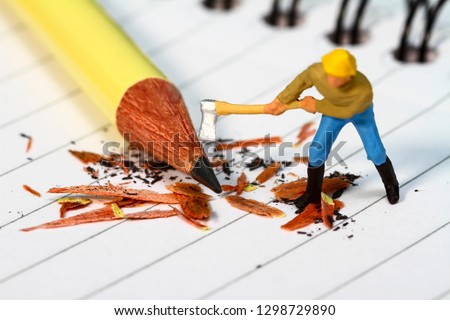Conceptual diorama image of a miniature figure sharpening a pencil on a note book