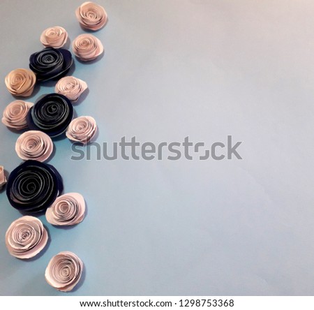 white background with three handmade blue roses and some white roses around