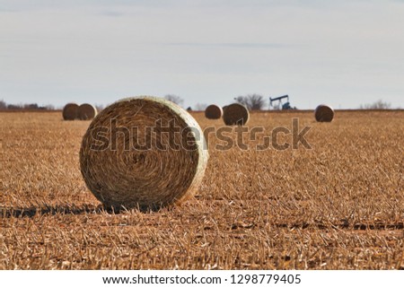 rolled hay and pump jack