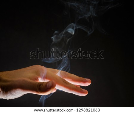 Smoke rising up through human hand. Spirits, spiritual background, witchcraft