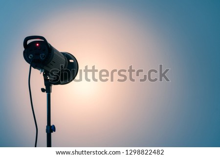 Studio light on the stand. Spotlight on white wall background. Copy space for text 