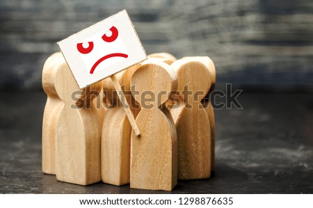An angry mob of wooden figures of people with a poster. Social discontent and social tension, protest and disagreement. People go outside and join the protest movement. Disobedience and disobedience. Royalty-Free Stock Photo #1298876635