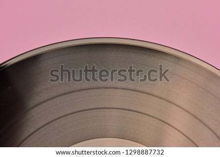 a fragment of a vinyl record on a pink background