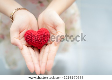 Red heart in hands from above. Healthy, love, donation organ, donor, hope and cardiology concept. Valentines day card.Giving love concept with hands holding a red heart.