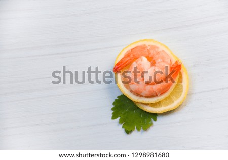Seafood with shrimps prawns ocean gourmet dinner cooked with green parsley herb and shrimp on lemon on white wood background top view 