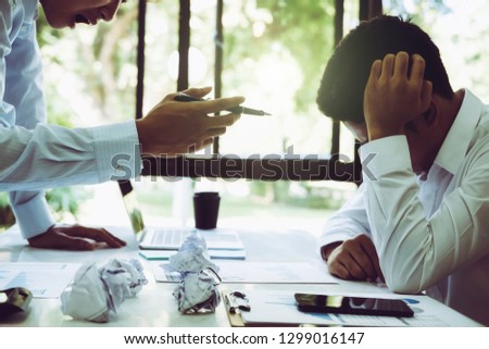 Stressed asian businessman getting trouble from mistake. conflict between male workers at workplace. Teamwork planners have conflict of interest between partner and coworker Royalty-Free Stock Photo #1299016147