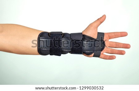 Man hand with adjustable immobilizer for injuries of bones and muscles.. Orthopedic device.human, dark, 