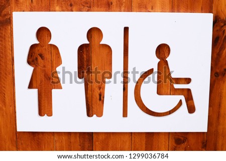 Restroom sign on a toilet door,on wood background.