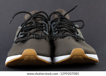 Close up picture of comfortable mens sneakers on grey background. New, fashionable, casual footwear