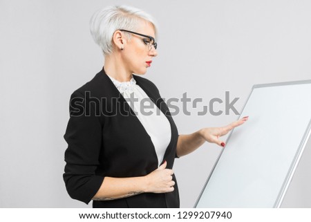 young girl with a magnetic Board in her hands stands isolated on a light background