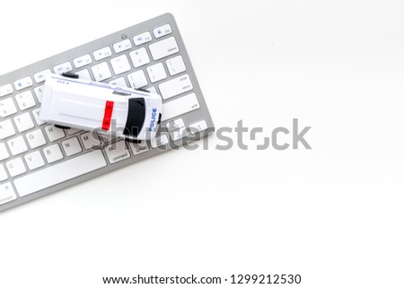 Call police online concept. Police car toy and computer keyboard on white background top view copy space