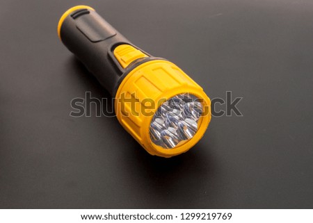 Yellow head led flashlight and black handle the emergency Led flashlight on black background, Handle led searchlight emergency tool.