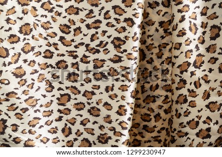silk fabric texture with pleats under leopard color abstract background