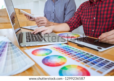 Team of Creative graphic designer meeting working on new project, choose selection color and drawing on graphics tablet with work tools and accessories.