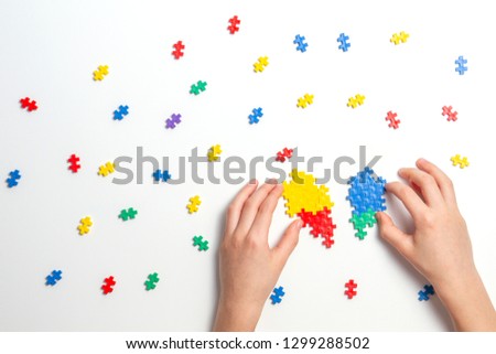 Child hands making multicolor heart on white background. Top view