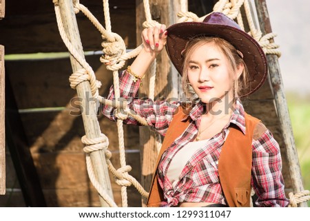 Outdoor portrait of beautiful young asian woman dressed as like a cowgirl at sunset time.Thailand