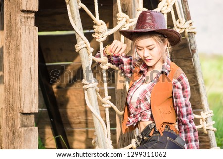 Outdoor portrait of beautiful young asian woman dressed as like a cowgirl at sunset time.Thailand
